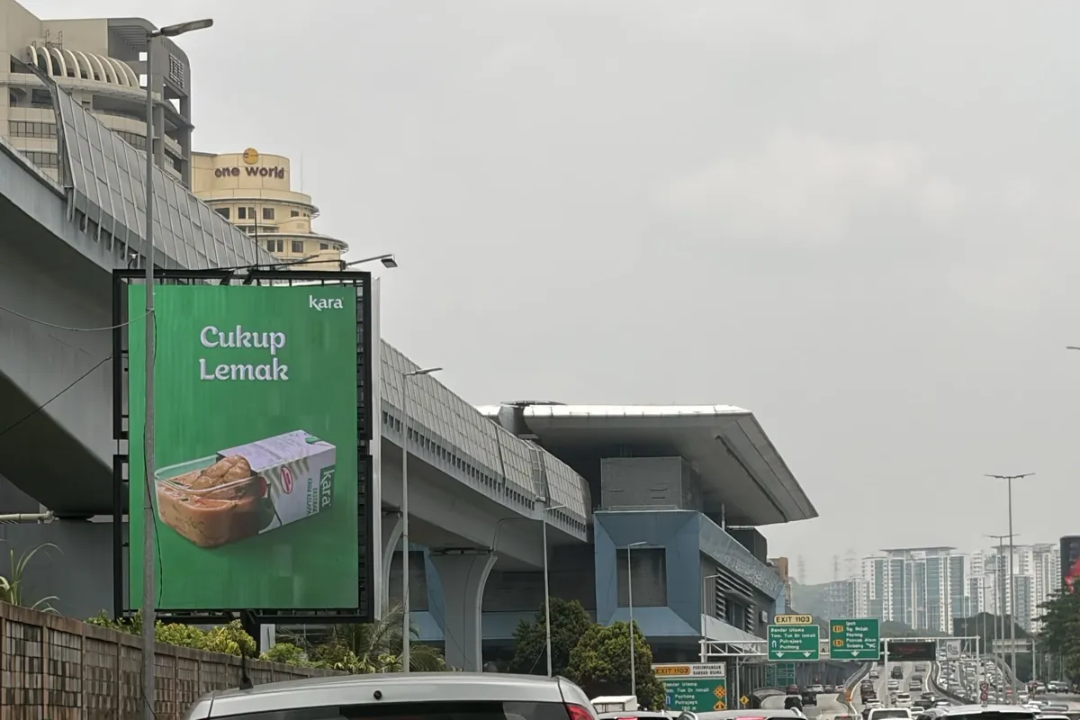 Kara Cukup Lemak digital billboard on the northbound LDP near 1 Utama, with the Exit 1103 Bandar Utama signs ahead