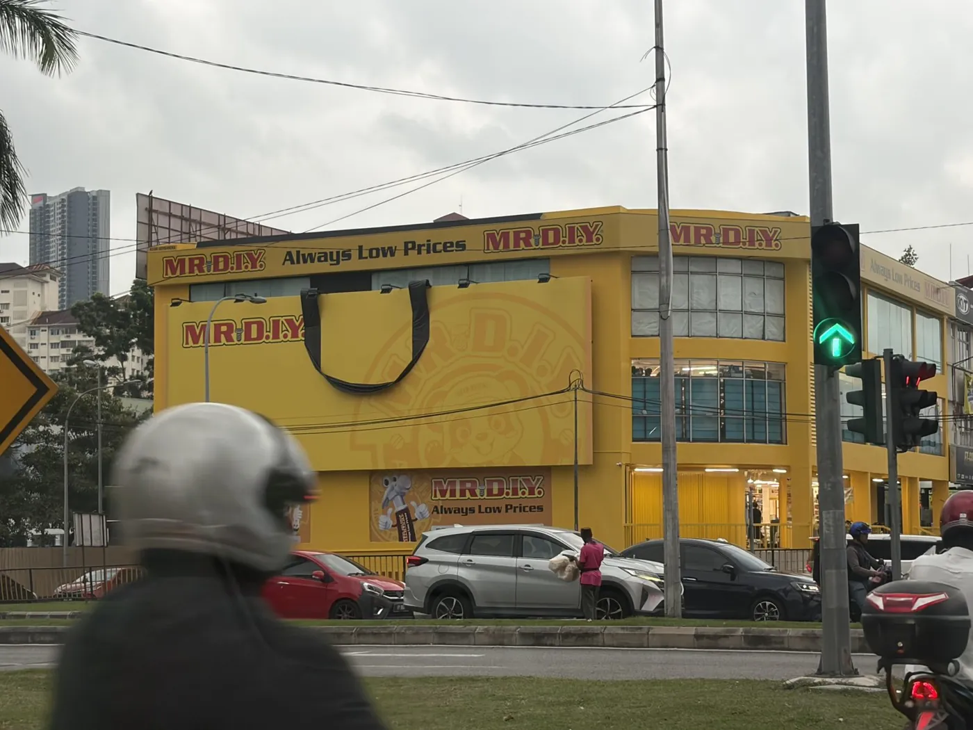 MR D.I.Y. store facade dressed as a giant yellow shopping bag with a 3D black handle, Kuala Lumpur